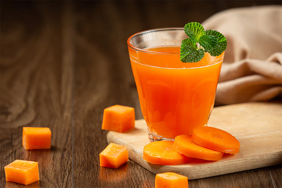 Often hailed for its vivid color, pleasant taste, and outstanding vitamin profile, carrot juice has become a health drink of choice. Though it has clear health advantages, others wonder if its natural sugar level qualifies for daily intake. To decide whether carrot juice merits a spot in your regular diet, let's weigh the advantages and drawbacks. What Is Carrot Juice? Extraction of the liquid from fresh carrots produces concentrated drink with most of the vegetable nutrients retained in carrot juice. To improve taste and nutritional worth, certain variants could call for other ingredients like ginger, lemon, or apples. The Benefits of Carrot Juice Rich in Vitamins and Minerals: Beta-carotene, a type of vitamin A, is found in great abundance in carrot juice, so supporting immune system, eye health, and skin condition. It also supplies potassium as well as vitamins C, K, and B6. High in Antioxidants: Carrot juice's beta-carotene and other antioxidants fight oxidative stress, therefore lowering the risk of chronic diseases and promoting general well-being. Supports Skin Health: The high Vitamin A content contributes to healthy skin by promoting cell turnover and protecting against damage from UV rays. Improves Immune Function: Popular during cold and flu season, carrot juice's mix of antioxidants and vitamin C boosts immune system strength. May Aid Digestion: While it lacks fiber, carrot juice contains enzymes and nutrients that may support digestion and maintain gut health. The Sugar Content in Carrot Juice Natural Sugars: About nine grams of sugar are in an eight-ounce glass of carrot juice. Although this is less than many fruit juices, it is nonetheless noteworthy and can cause blood sugar increases when drunk excessively. Lack of Fiber: Juicing removes most of the fiber present in whole carrots, which otherwise helps regulate sugar absorption and promotes satiety. Glycemic Impact: Carrot juice has a mild glycemic index even with its natural sugars. It can be lessened in effect on blood sugar levels by combining it with protein or good fats. Potential Drawbacks of Carrot Juice Caloric Content: Although nutrient-dense, carrot juice has more calories than water or herbal teas. Eating too much could cause inadvertent calorie consumption. Overconsumption of Vitamin A: Too much carrot juice can result in an oversupply of beta-carotene, which would give the skin a benign but obvious orange tinge known as carotenemia. Dental Health Concerns: The natural sugars and acidity in carrot juice can contribute to tooth decay if consumed frequently without proper oral hygiene. How to Enjoy Carrot Juice Mindfully Control Portion Sizes: Stick to small servings (4 to 6 ounces) to enjoy the benefits without overloading on sugar or calories. Pair with Whole Foods: To regulate blood sugar, mix carrot juice with a meal or snack including fiber, protein, and good fats. Choose Fresh or Homemade Juice: Choose freshly prepared carrot juice free of preservatives or extra sweeteners. If purchasing store-bought, carefully check labels to be sure it is 100% juice. Dilute with Water: While still making a cool drink, mixing carrot juice with water or sparkling water helps to lower sugar concentration. Incorporate in Smoothies: To make a more balanced drink, blend carrot juice with other nutrient-dense foods such as spinach, ginger, or unsweetened yogurt. The Role of Carrot Juice in a Balanced Diet When used in moderation, carrot juice may be a great supplement to any balanced diet. Particularly for people who find it difficult to eat enough veggies, its nutrient density makes it a great choice for a rapid vitamin boost. It should, nevertheless, enhance entire foods rather than replace them. Conclusion Clearly a nutrient-dense beverage, carrot juice provides a variety of health advantages from better skin to a stronger immune system. But its natural sugar level and lack of fiber make it ideal for moderation. Knowing its advantages and drawbacks will help you to include carrot juice into your diet in a way that supports general health without overindulging in sweetness. Like any health trend, awareness and balance are absolutely vital.